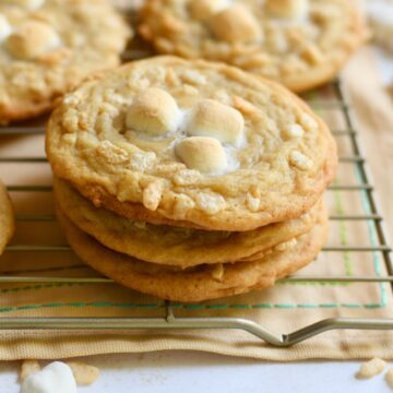 Three rice krispie cookies stacked on top of each other on a cooling rack.