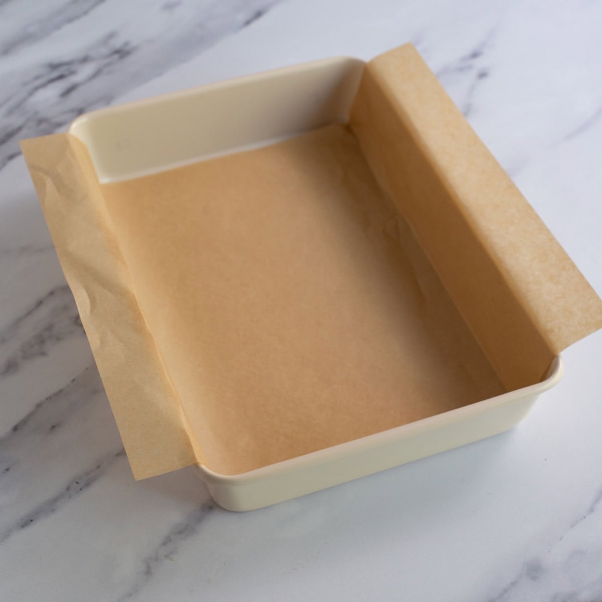 Parchment placed in a baking dish with some overhang.