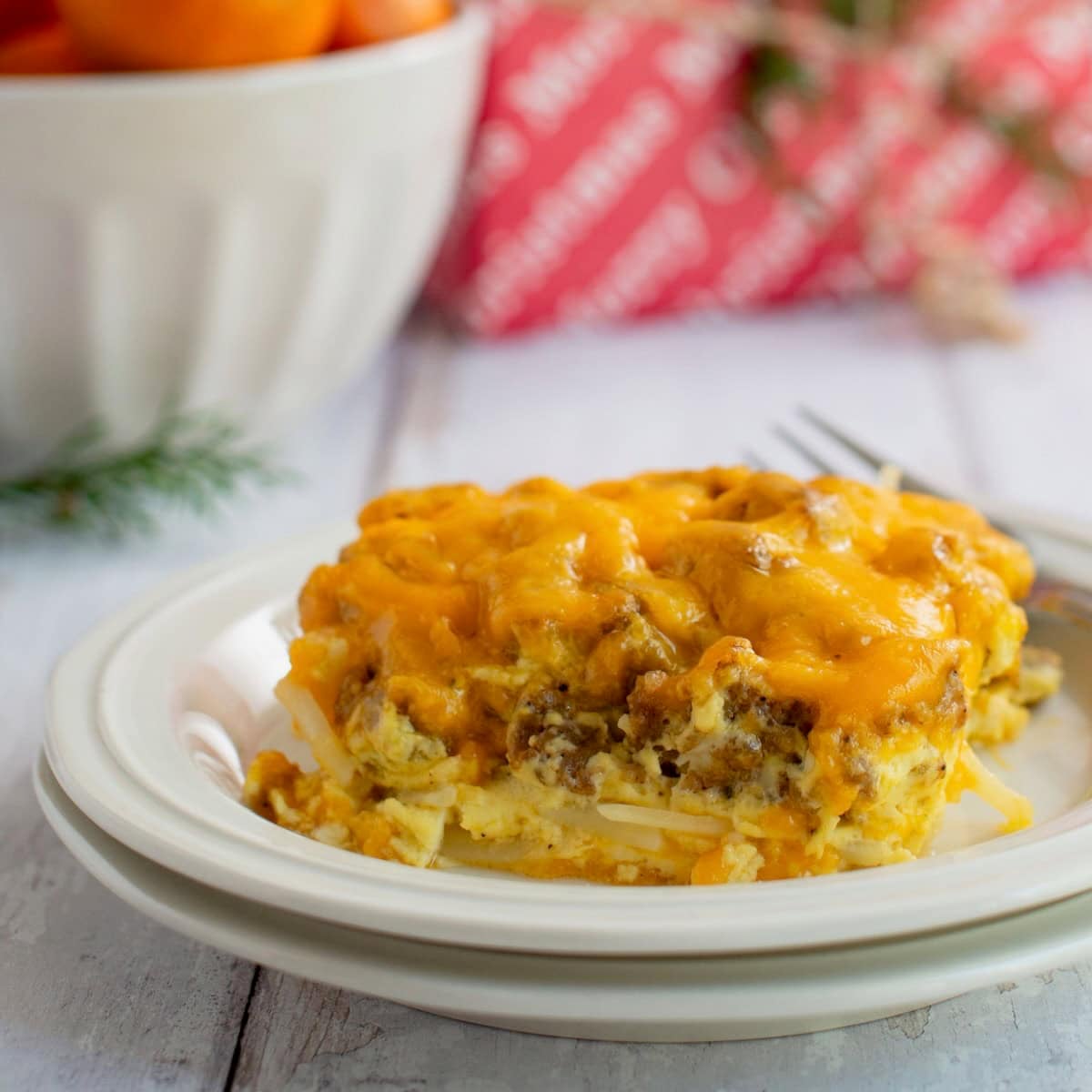 Side view of a square of sausage and hashbrown casserole on a plate.