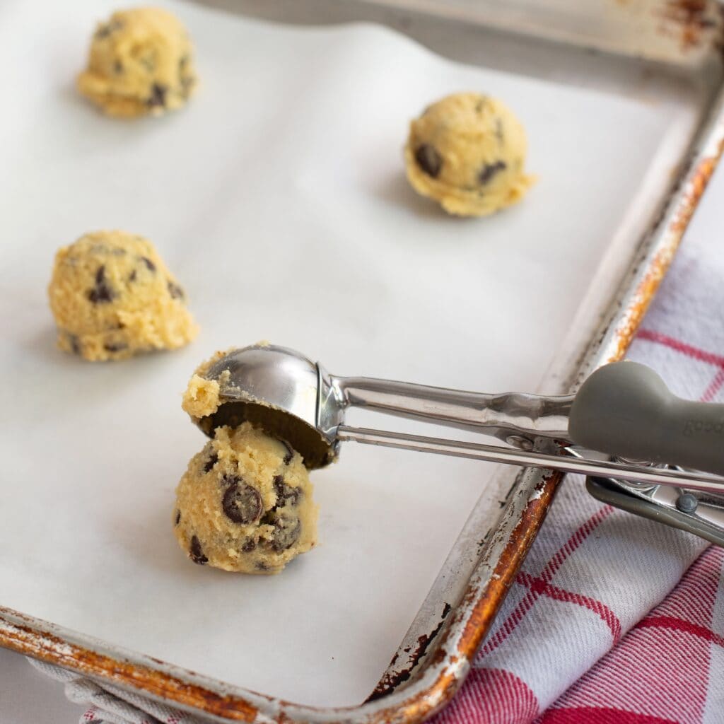 Using a cookie scoop to place cookie dough on a sheet pan.